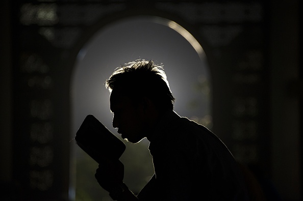 A Muslim prays over a Quran.  