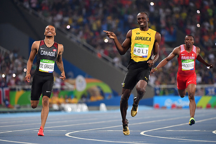 Jamaica's Usain Bolt jokes with Canada's Andre De Grasse after they crossed the finish line in the men's 200m semi-final during the athletics event at the Rio 2016 Olympic Games on August 17, 2016. 