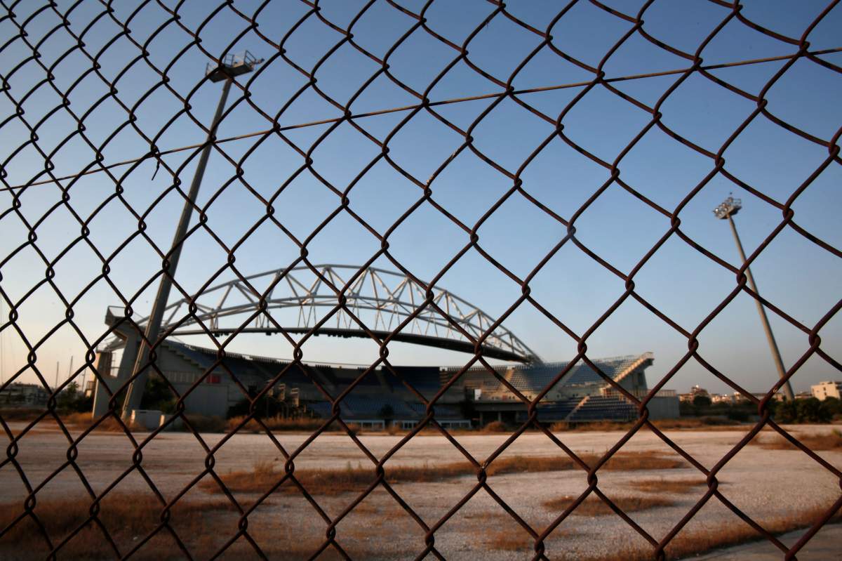The abandoned stadium which hosted the beach volleyball competition during the Athens 2004 Olympic Games is seen behind a fence at the Faliro complex south of Athens July 22, 2014. REUTERS/Yorgos Karahalis