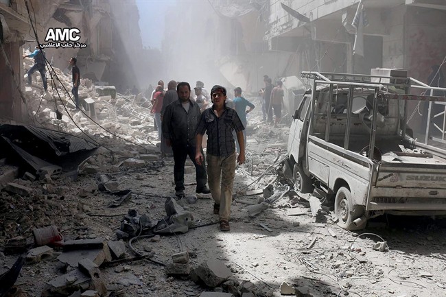 Residents survey damage in Aleppo, Syria, in this file photo. US-led coalition airstrikes killed 54 civilians in Syria and Iraq from March to October, the U.S. military says.