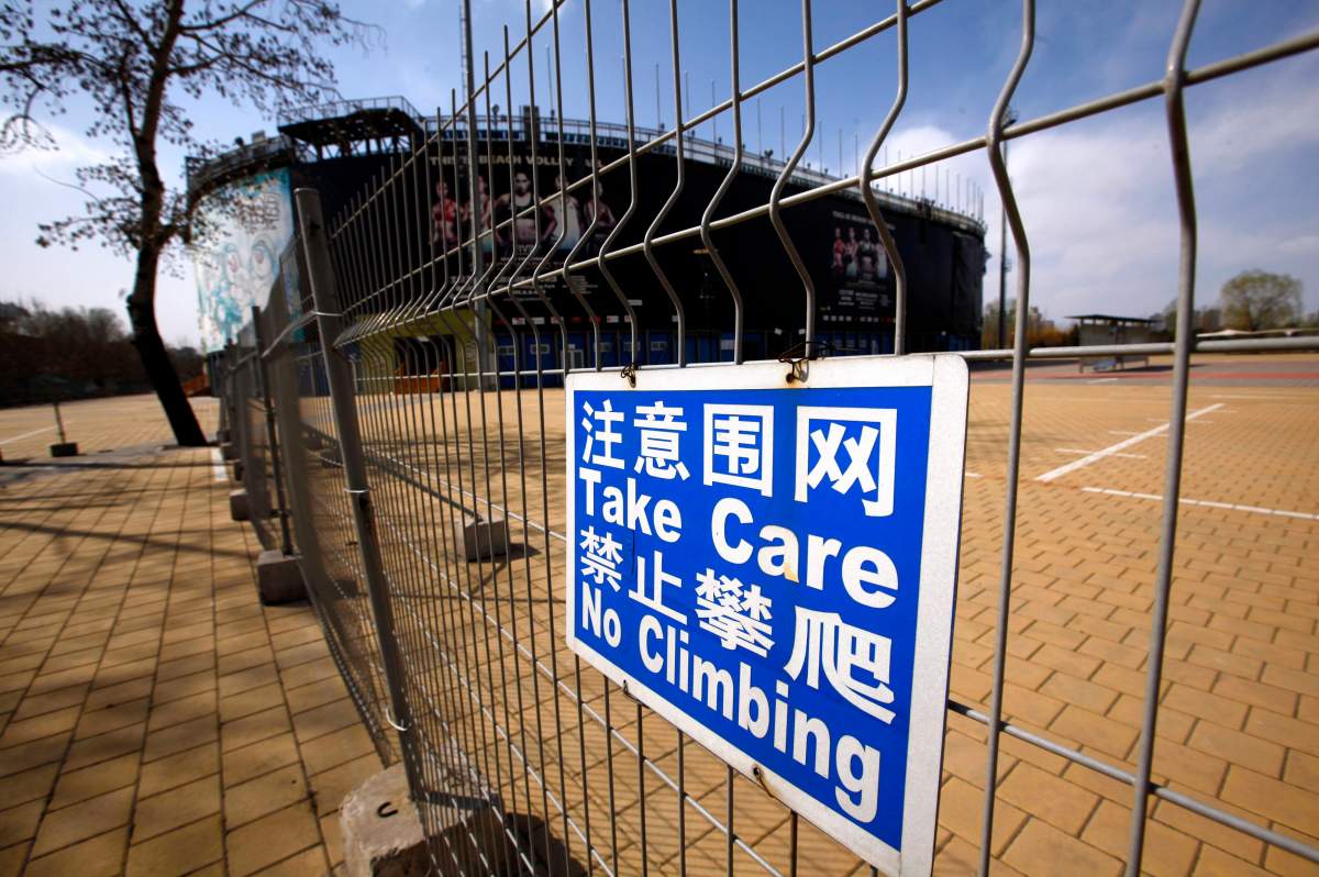 A security fence surrounds the deserted and unmaintained 2008 Beijing Olympics venue for the beach volleyball competition in central Beijing April 2, 2012. REUTERS/David Gray