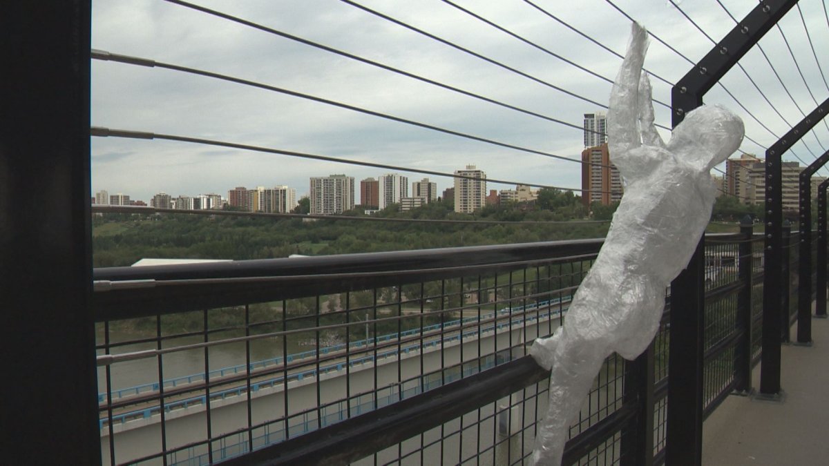 As many as five life-size human sculptures made entirely of tape were set up in various poses dangling off the suicide barriers along the High Level Bridge Sunday morning.