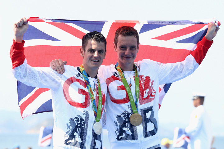 Gold medalist Alistair Brownlee and silver medalist Jonathan Brownlee of Great Britain celebrate on the podium during the Men's Triathlon