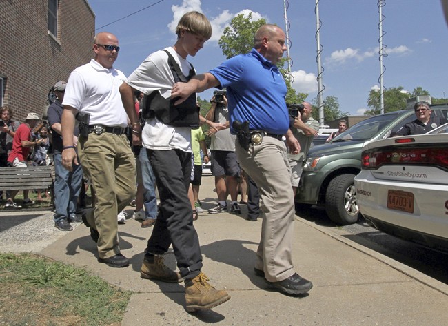 In this Thursday, June 18, 2015 file photo, Charleston, S.C., shooting suspect Dylann Storm Roof is escorted from the Shelby Police Department in Shelby, N.C. 