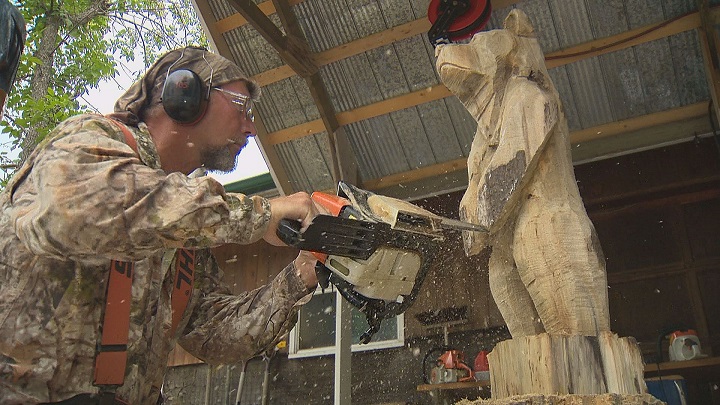 Jim Niedermayer works on a sculpture of a bear while preparing for an upcoming chainsaw carving competition. 