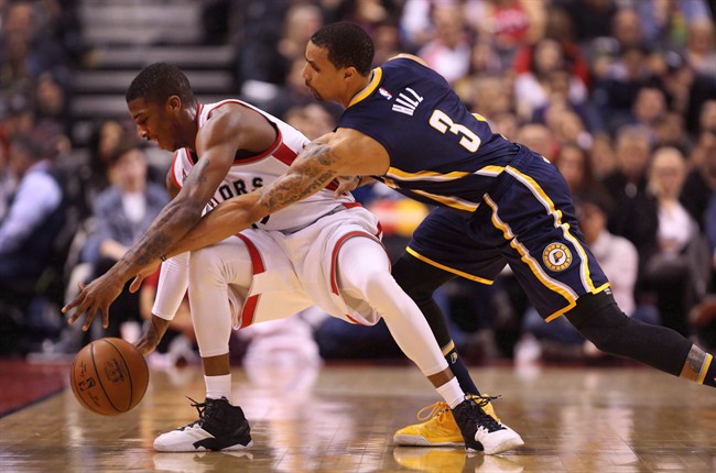 Toronto Raptors guard Delon Wright (55) nearly has the ball stripped away by Indiana Pacers guard George Hill (3) during the second half of NBA Basketball action in Toronto on Friday, April 8, 2016. 
