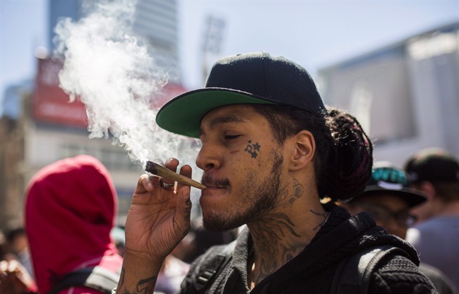 A man smokes a marijuana joint during the "420 Toronto" rally in Toronto, Wednesday April 20, 2016.
