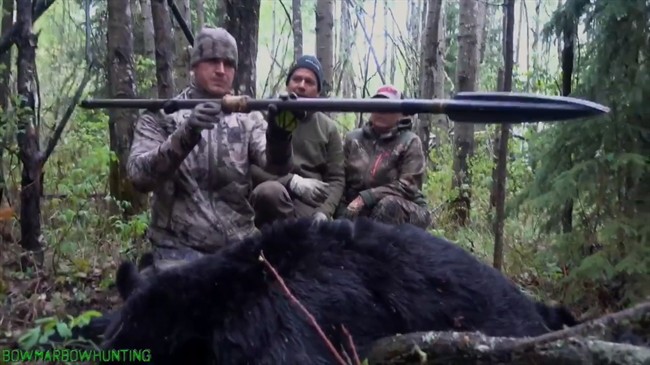 American Josh Bowmar, seen here at left in a still image made from video, displays the spear with which he killed a large black bear, which resulted in a public backlash in 2016.
