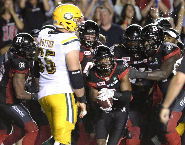 The Ottawa Redblacks celebrate with Jermaine Robinson (2) after making an interception as Edmonton Eskimos Simeon Rottier (65) looks on during second half CFL action on Saturday, Aug. 6, 2016 in Ottawa.