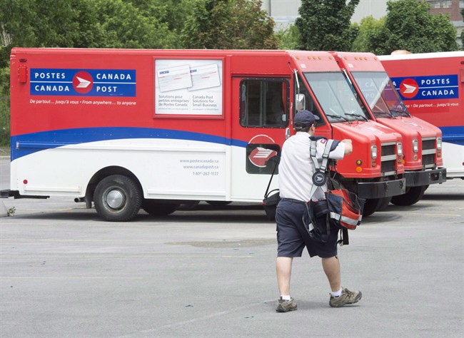 A postal worker walks past Canada Post trucks at a sorting centre in Montreal, Friday, July 8, 2016. As the clock ticks down on the Canadian Union of Postal Workers' strike mandate, contract talks with Canada Post are going nowhere fast.