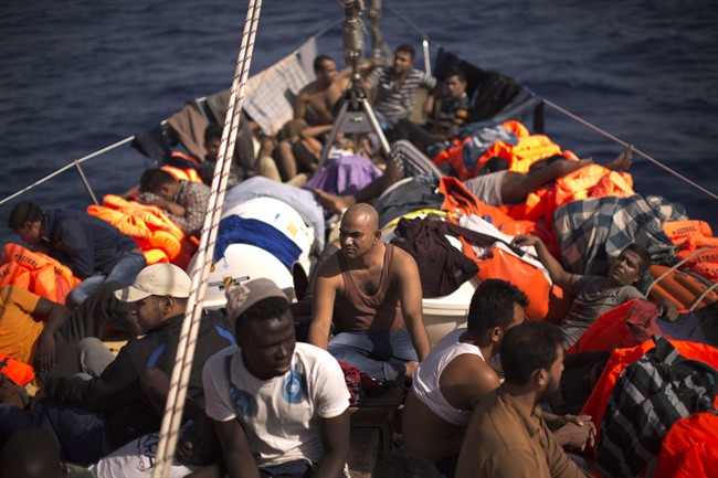 Migrants sit aboard a rescue boat after fleeing Libya in this file photo. Officials say 90 migrants died at sea Thursday when their boat collapsed.