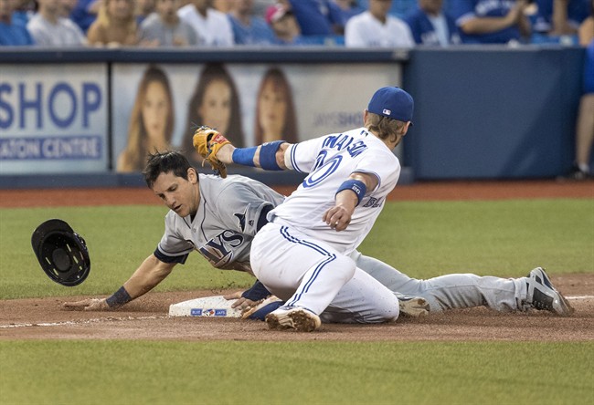 Tampa Bay Rays' Mikie Mahtook, left, slides safely under the tag attempt at third base by Toronto Blue Jays' Josh Donaldson during the fourth inning of their baseball game in Toronto on Monday, Aug. 8, 2016.