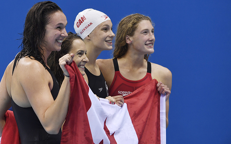 Team Canada, Canada's Sandrine Mainville, Canada's Chantal van Landeghem, Canada's Taylor Ruck and Canada's Penny Oleksiak celebrate after they won bronze in the Women's 4 x 100m Freestyle Relay Final during the swimming event at the Rio 2016 Olympic Games at the Olympic Aquatics Stadium in Rio de Janeiro on August 6, 2016.