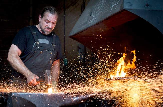 Master Blacksmith Mathieu Collette forges a piece of iron at his workshop in Montreal, Wednesday, August 10, 2016. 