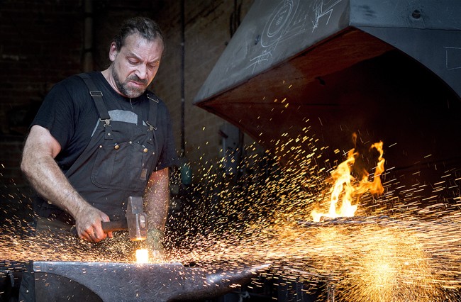 Master Blacksmith Mathieu Collette forges a piece of iron at his workshop in Montreal, Wednesday, August 10, 2016. 