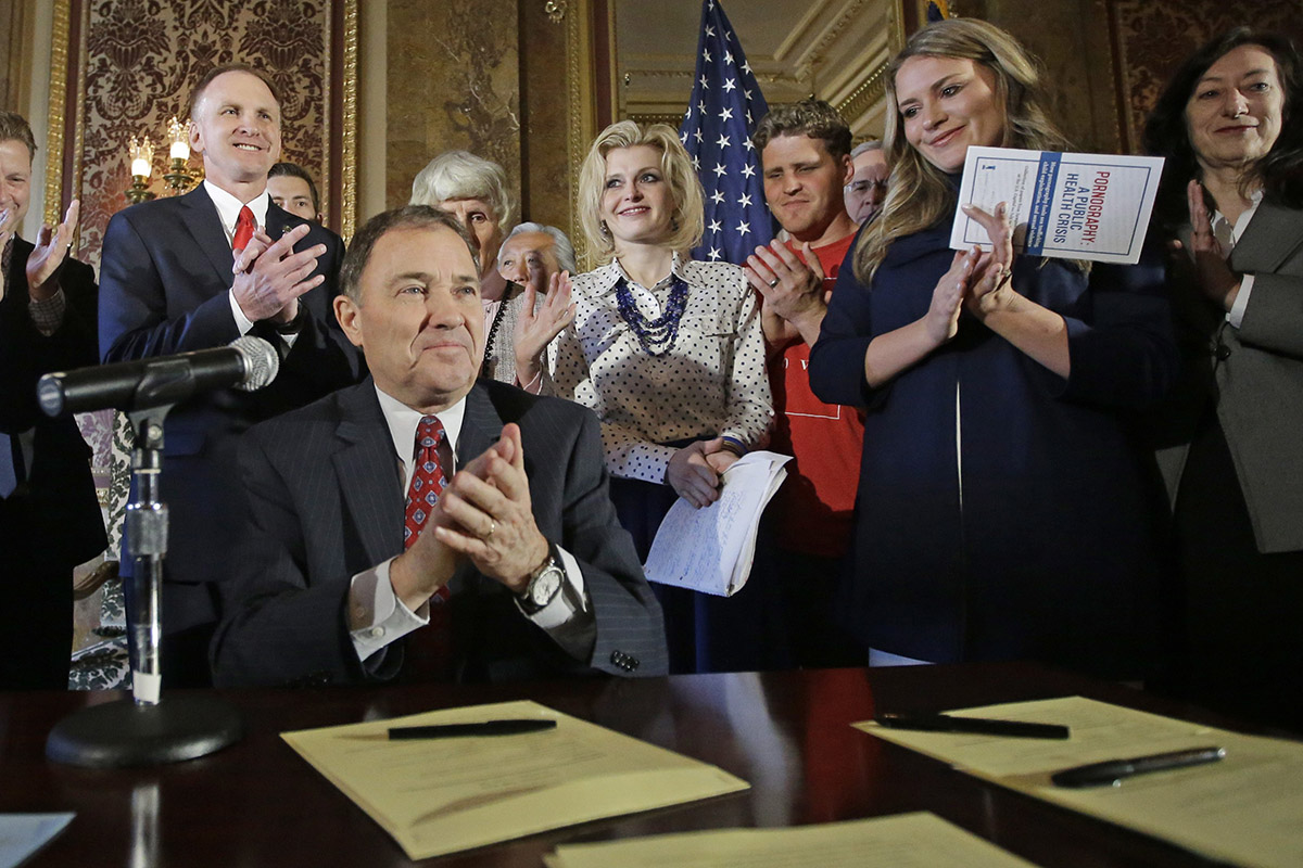 In this April 19, 2016, file photo, Utah Gov. Gary Herbert and supporters applaud during a ceremonial signing of a state resolution declaring pornography a public health crisis in Salt Lake City, Utah. 