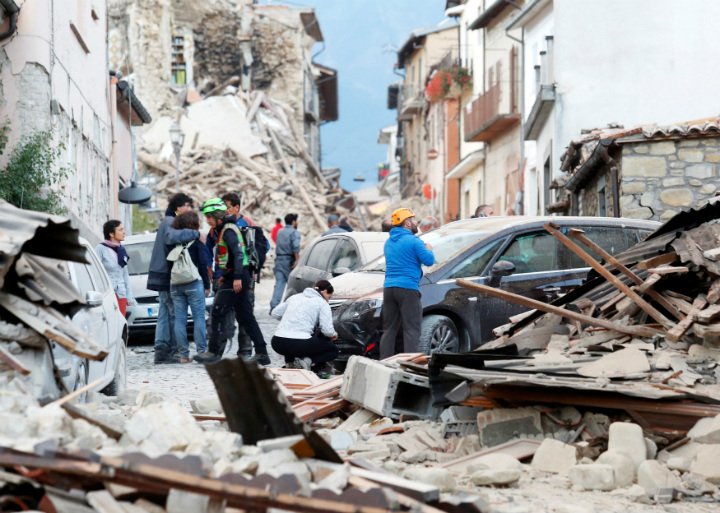 People stand along a road following a quake in Amatrice, central Italy, August 24, 2016. 