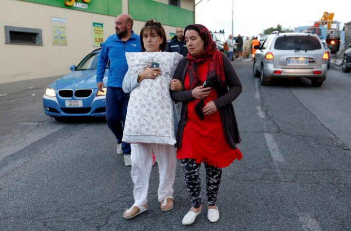 People walk along the road following a quake in Amatrice, central Italy, August 24, 2016. 