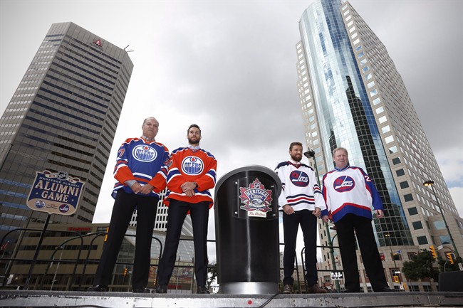 Edmonton Oilers alumnus Dave Semenko, Oilers goaltender Cam Talbot, Winnipeg Jets forward Blake Wheeler and Jets alumnus Thomas Steen show off the Heritage Classic jerseys as the National Hockey League announce the rosters at a Tim Hortons NHL Heritage Classic press event at Winnipeg's Portage and Main intersection on Friday, August 5, 2016. 