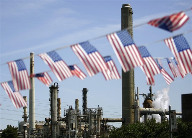 FILE - In this April 30, 2008 file photo, American flags are seen near the Shell refinery, in Martinez, Calif. The state is set to extend an ambitious climate change law.