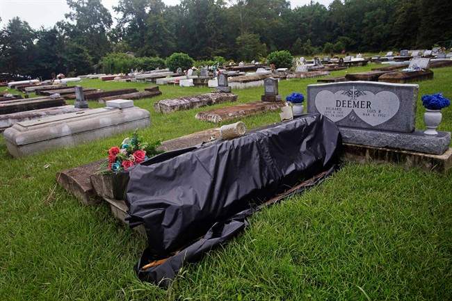 A flood damaged tomb is covered for repair at the cemetery of Greater St. Mark Baptist Church in Walker, La., Tuesday, Aug. 16, 2016.