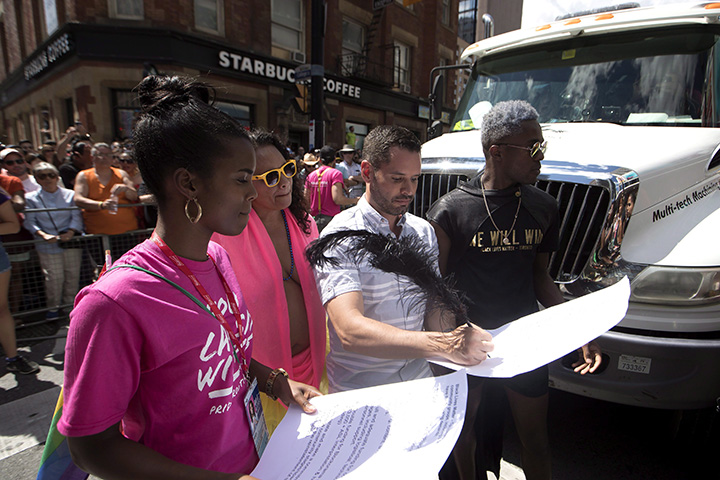 Mathieu Chantelois signs a list of demands from the Black Lives Matters movement as they stage a sit-in at the annual Pride Parade in Toronto on Sunday, July 3, 2016.