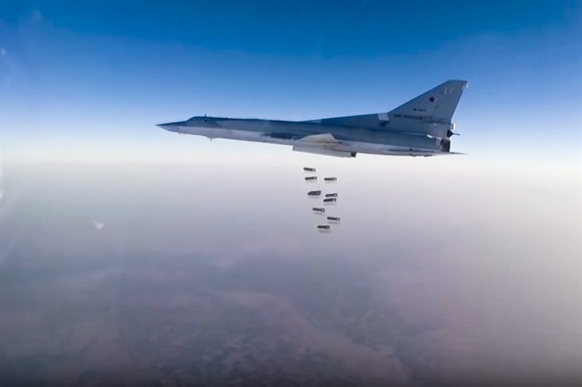 In this frame grab from video provided by the Russian Defence Ministry Press Service, Russian long range bomber Tu-22M3 flies during a strike above an undisclosed location in Syria on Sunday, Aug. 14, 2015. Russia denies it has plans for new military bases in Syria.