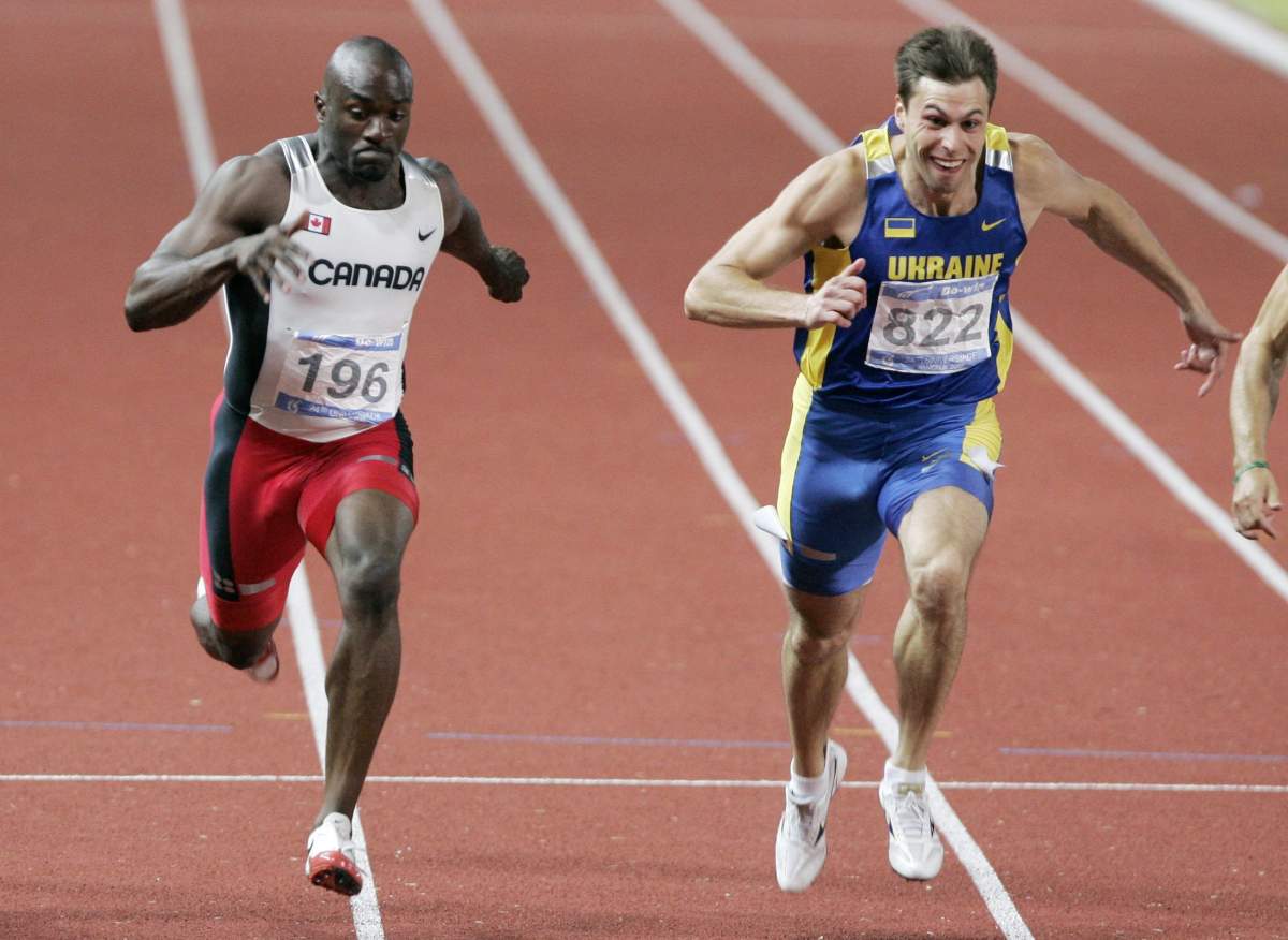 Canada’s Neville Wright, left, and Ukraine’s Okena Chebanu, right, cross the finish line for the men’s 100 meter sprint final at the 24th World University Games in Pathumthani province, Thailand Saturday, Aug. 11, 2007.