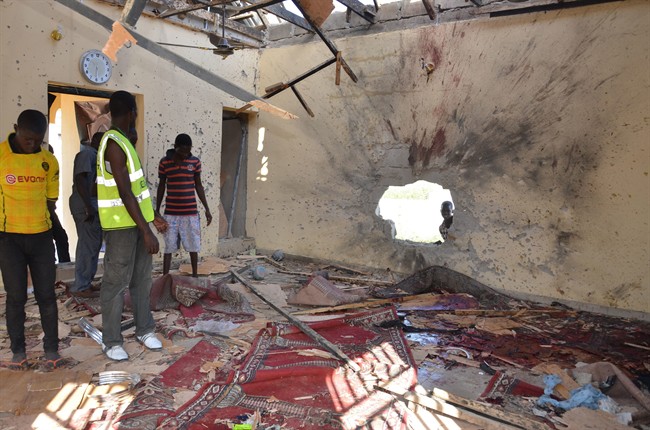  In this Friday, Oct. 23, 2015 file photo, people inspect a damaged mosque following an explosion in Maiduguri, Nigeria.