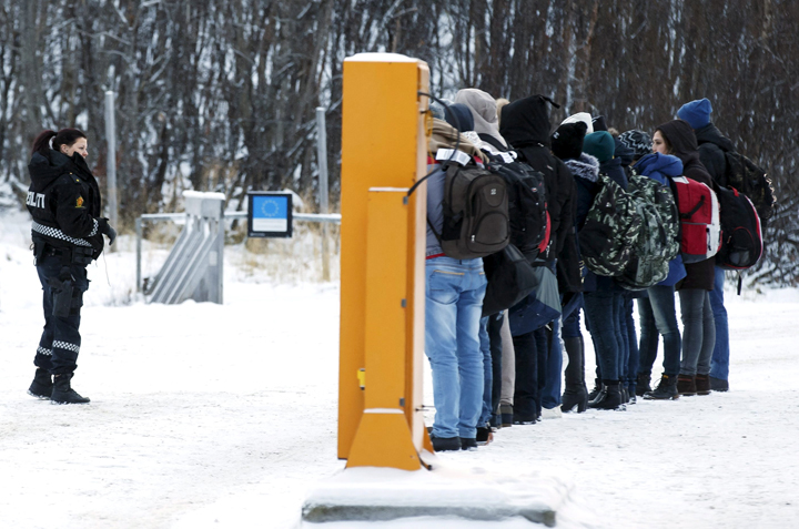 Migrants receive instructions from a Norwegian police officer at the Storskog border crossing station near Kirkenes, after crossing the border between Norway and Russia, November 16, 2015.