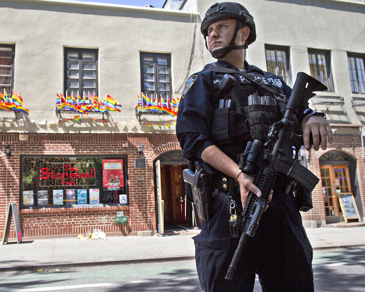 In this June 12, 2016 file photo, an armed police officer stands guard outside the Stonewall Inn, in New York after a Florida gunman's attack at a gay nightclub spread fear of more attacks. 
