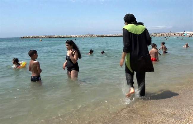  In this Aug.4 2016 file photo made from video, Nissrine Samali, 20, gets into the sea wearing traditional Islamic dress, in Marseille, southern France. 