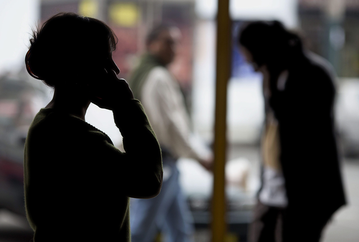 Pedestrians talk on their cellphones in Lima, Peru, on Monday, Aug. 1, 2016. 