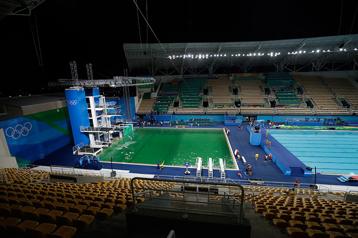 The water of the diving pool at left appears a murky green, in stark contrast to the pool's previous day's colour and also that of the clear blue water in the second pool for water polo at the venue as divers train in the Maria Lenk Aquatic Centre at the 2016 Summer Olympics in Rio de Janeiro, Brazil, Tuesday, Aug. 9, 2016. 