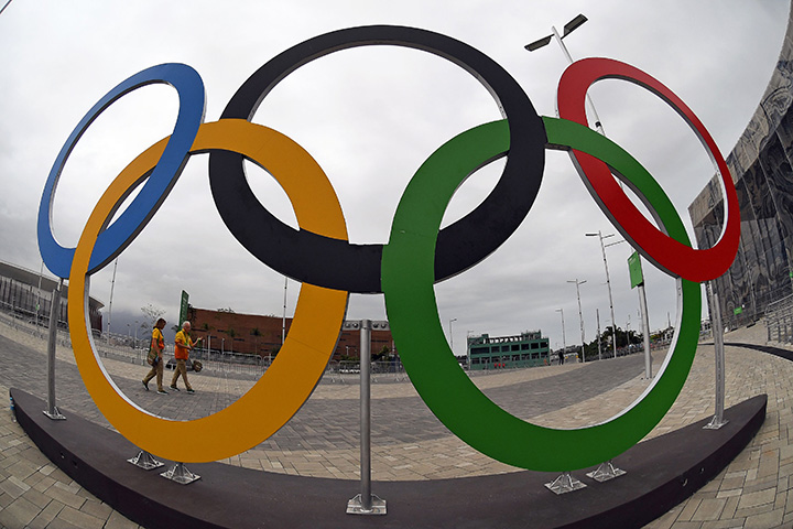  Volunteers walk past a set of Olympics Rings at the Olympics Park in Rio de Janeiro on August 3, 2016 ahead of the Olympic Games.