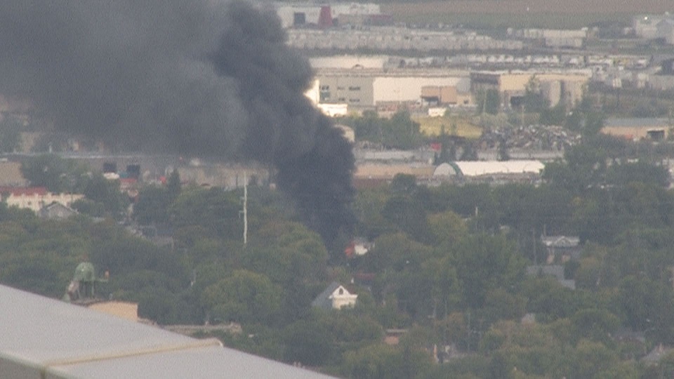 Smoke and flames can be seeing coming from a building on Ross Avenue West in Winnipeg.