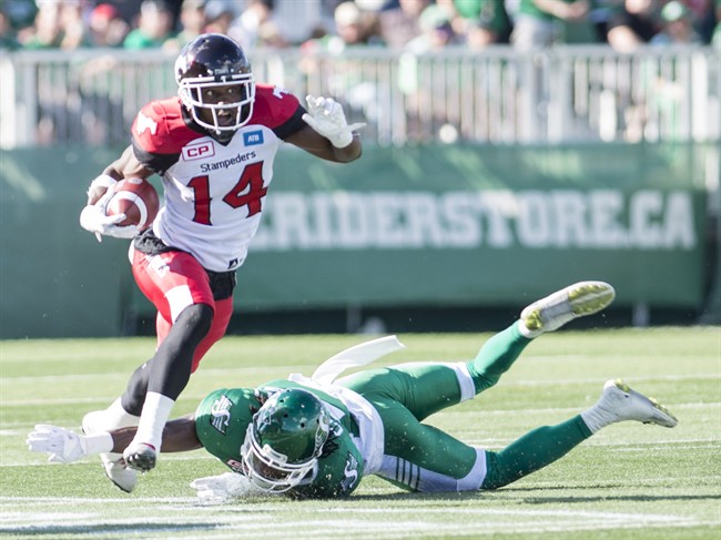 algary Stampeders running back Roy Finch (14) avoids a tackle from Saskatchewan Roughriders defensive back Major Culbert (22) during the first half of CFL football action in Regina on Saturday, August 13, 2016.