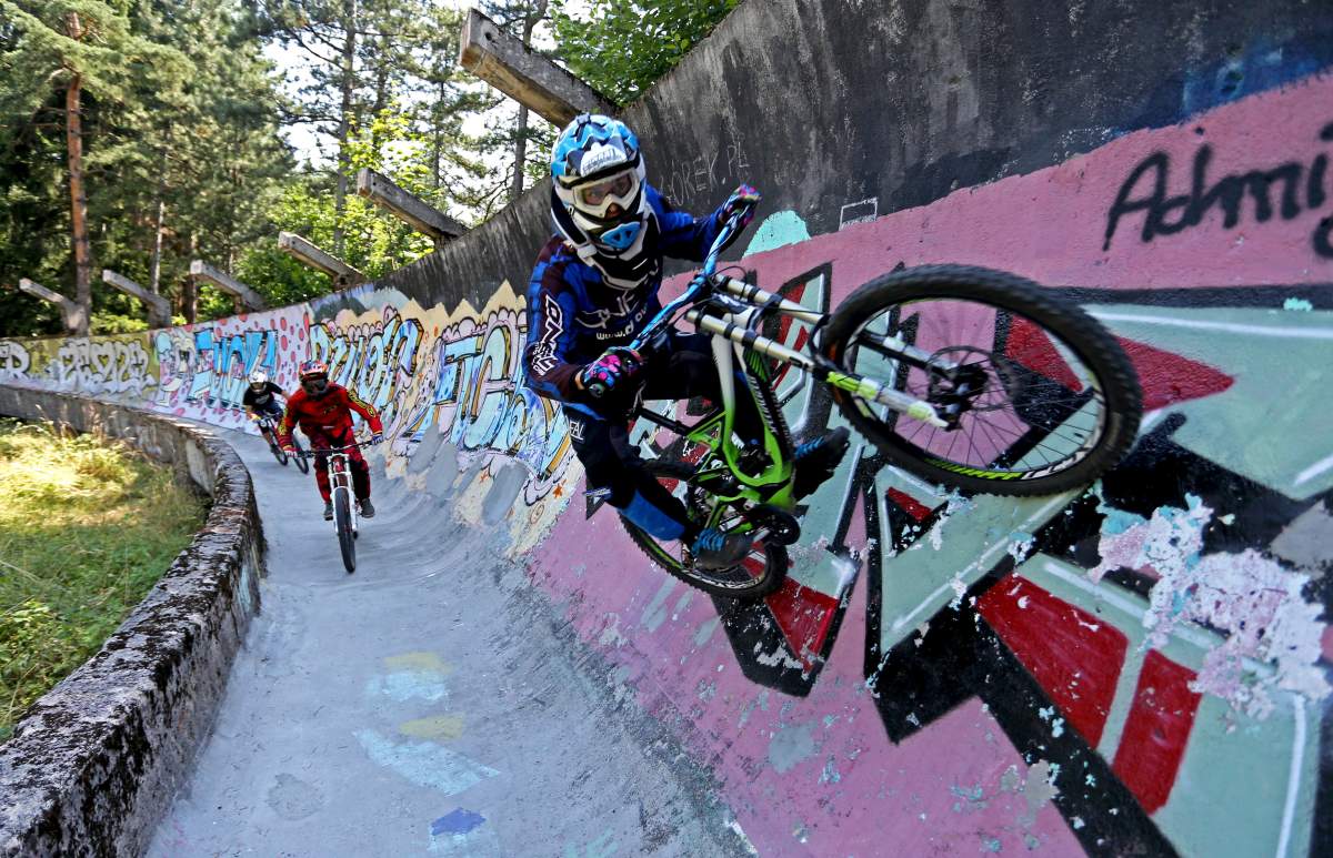 Downhill bikers Kemal Mulic (C), Tarik Hadzic (L) and Kamer Kolar train on the disused bobsled track from the 1984 Sarajevo Winter Olympics on Trebevic mountain near Sarajevo, Bosnia and Herzegovina, August 8, 2015. REUTERS/Dado Ruvic