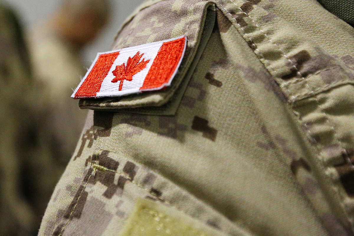 The Canadian flag is seen on the shoulder of a soldier waiting to board an Airbus CC-150 Polaris at CFB Trenton in Trenton, Ont., on Oct. 16, 2014. 
