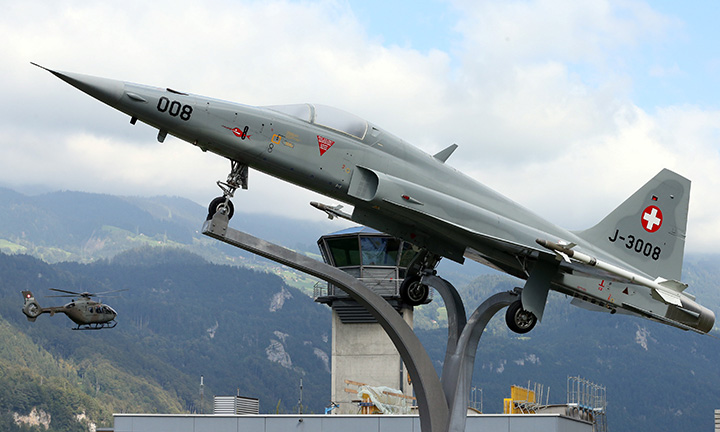 A Swiss Army Airforce helicopter is seen approaching near a displayed Northrop F-5 ll Tiger fighter jet at the military airport in Meiringen, Switzerland August 30, 2016. 