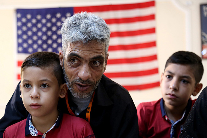 In this photo taken Sunday, August 28, 2016, Syrian refugee Nadim Fawzi Jouriyeh, 49, speaks to reporters at the Amman, Jordan office of the International Organization for Migration. Jouriyeh is flanked by his sons Farouq, 8, and Hamzeh, 12. The six-member Jouriyeh family will head to San Diego, California, as part of a year-long program to resettle 10,000 Syrian refugees in the United States. 