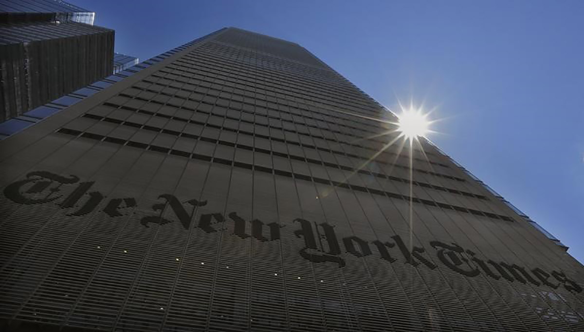 The sun peaks over the New York Times Building in New York August 14, 2013. 