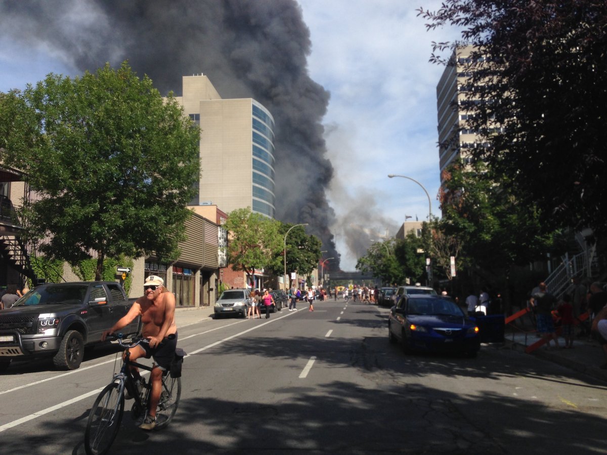 Residents evacuate following a fiery explosion on Highway 40, above Saint-Denis Street, Tuesday, August 9, 2016.