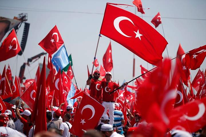 Protesters wave Turkish flags as they take part in a Democracy and Martyrs' Rally in Istanbul, Sunday, Aug. 7, 2016.