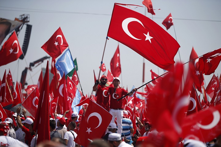 Protesters wave Turkish flags as they take part in a Democracy and Martyrs' Rally in Istanbul, Sunday, Aug. 7, 2016.