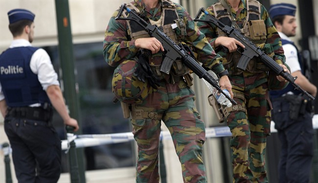 FILE - In this June 23, 2016, file photo, folice and Belgian Army soldiers patrol during a court hearing for suspect Mohamed Abrini, a suspect in the Paris and Brussels attacks, that were claimed by the Islamic State organization, at the Court of Appeals in Brussels.