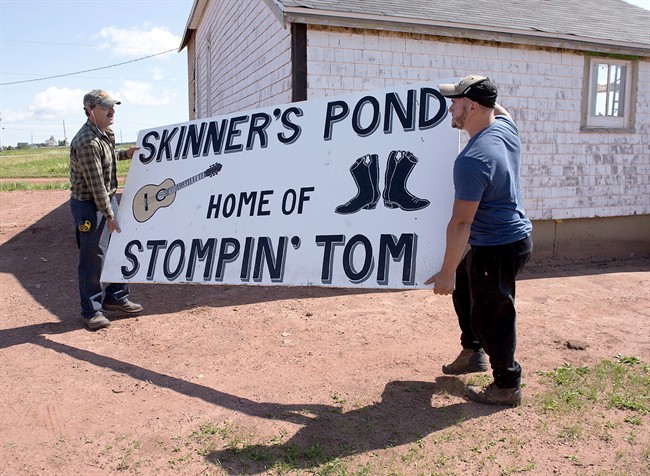 Workers move a sign at the site of the proposed Stompin Tom Connors cultural centre in Skinners Pond, P.E.I. on Wednesday, Aug. 3, 2016. 