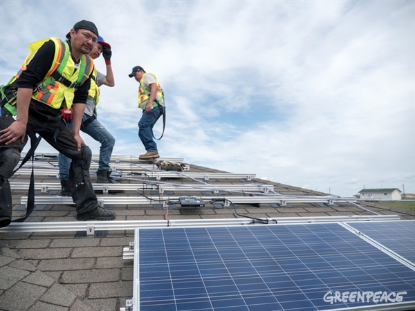 A file photo of workers installing solar panels.