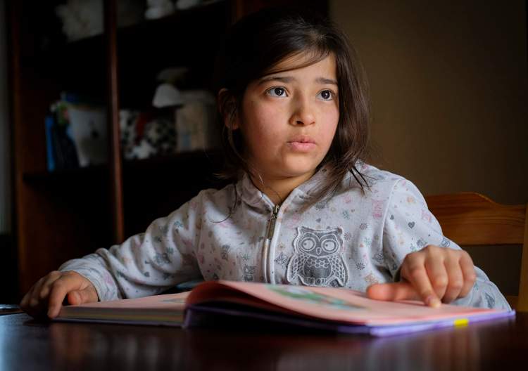 Syrian refugee Rim Younis, 12, practices her English reading skills at her home in Calgary, Alta., .
