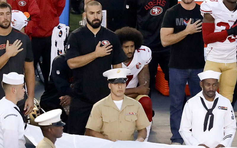 San Francisco 49ers quarterback Colin Kaepernick, middle, kneels during the national anthem before the team's NFL preseason football game against the San Diego Chargers, Thursday, Sept. 1, 2016, in San Diego. 